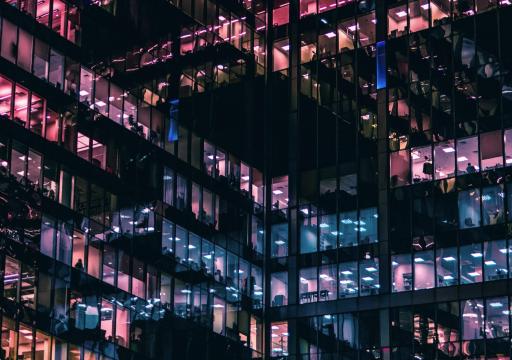 Valaistut rakennuksen ikkunat pimeässä kaupunkiympäristössä