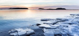 Jäätä järven rannalla ja auringonlasku